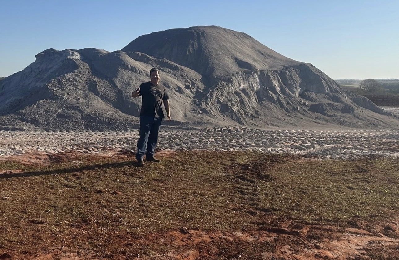 Fausto em frente a uma montanha de calcário na fazenda