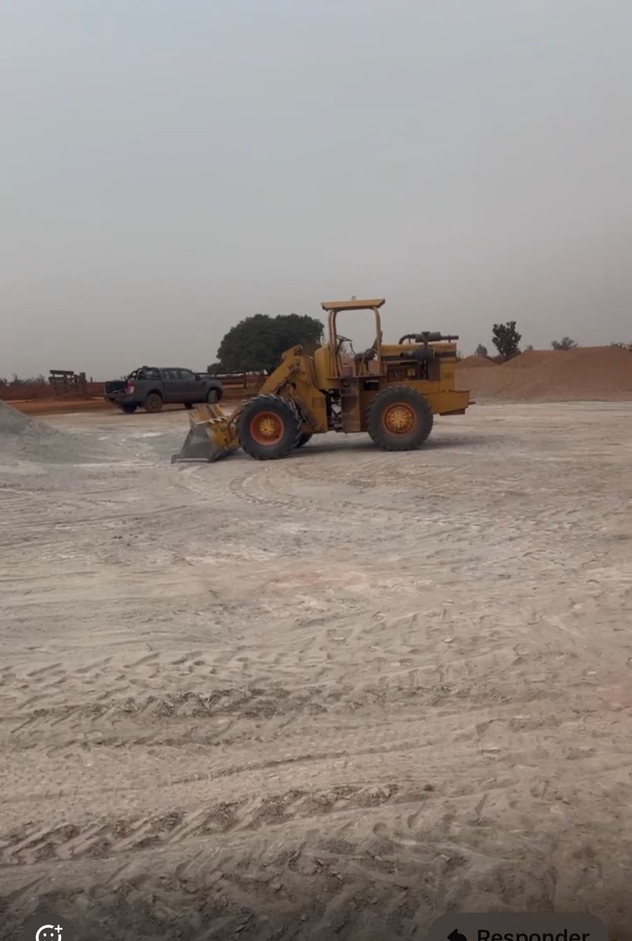 Pá-carregadeira movimentando calcário no pátio da fazenda